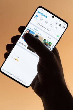 New York, ABD - 4 Kasım 2022: Kahverengi arka planda el altında tutulan akıllı telefon uygulaması