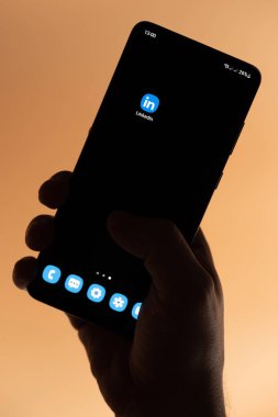 New York, ABD - 4 Kasım 2022: Elde tutulan akıllı telefon uygulaması kahverengi arka planda izole edildi