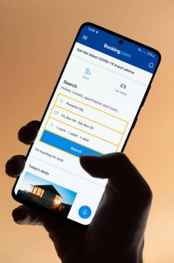 New York, ABD - 4 Kasım 2022: Kahverengi arka planda elde tutulan akıllı telefon uygulaması