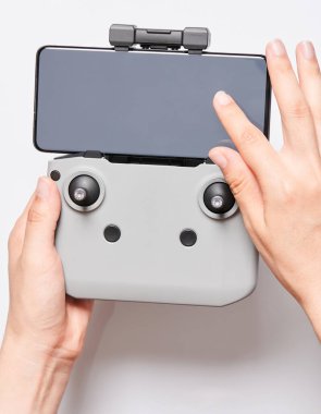 Stüdyo arka planında izole akıllı telefon ile uzaktan kumanda kullanmak