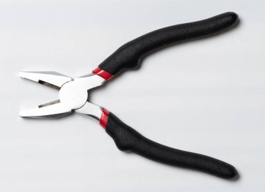 Stüdyo arka planında siyah kauçuk kabzalı açık çelik pense.