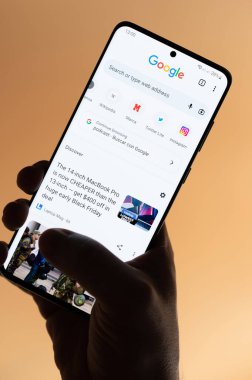New York, ABD - 4 Kasım 2022: Kahverengi arka planda el altında tutulan akıllı telefon uygulaması kullanılıyor