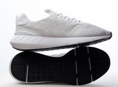 Stüdyo arka planında izole edilmiş spor ayakkabılarının taban ve arka görünümü