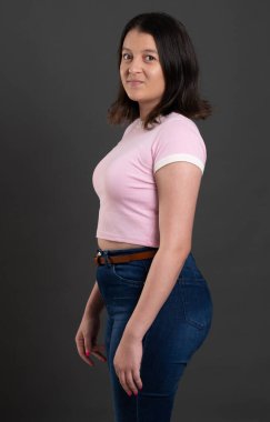 Stüdyo arka planında gündelik kıyafetli büyük boy Latin modelinin profil görünümü