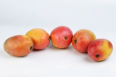 Stüdyonun arka planında olgun kırmızı mango meyveleri vardı.