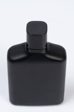 Stüdyo arka planında izole edilmiş temiz siyah parfüm şişesi.