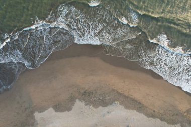 Günbatımında boş bir kumsal İHA görüntüsünün üstünde havadan.