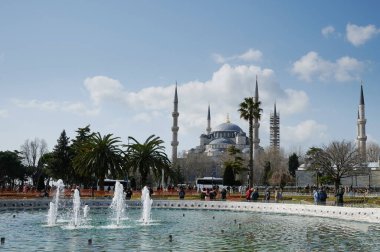 İstanbul, Türkiye - 24 Mart 2022: Turist güneşli bir günde İstanbul 'da mavi cami geçmişiyle fotoğraf çekiyor
