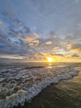 Gün batımında küçük okyanus dalgaları dramatik gökyüzü arkaplanı