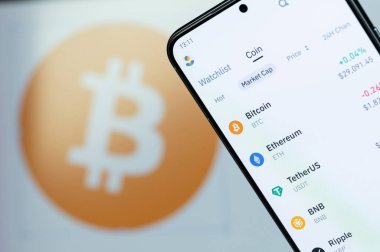 New York, ABD - 6 Ağustos 2023: Akıllı telefon ekranında Binance uygulamasında Bitcoin fiyatı bulanık logo arka planıyla yakın plan