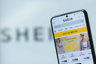 New York, ABD - 20 Ağustos 2023: Akıllı telefon ekranındaki Shein shop uygulaması ile çevrimiçi promosyon satın almak bulanık logo arka planıyla yakın plan