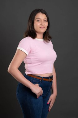 Genç model artı boyut Latin kökenli gri stüdyo arka planında izole edilmiş.