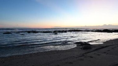 Okyanus sahili üzerinde gün batımında yüksek çözünürlüklü ses