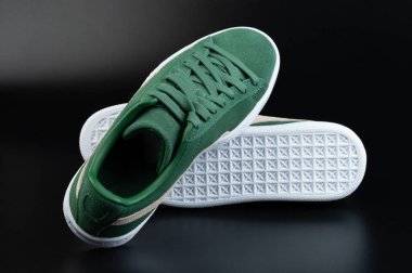 Siyah arka planda izole edilmiş beyaz tabanlı bir çift yeşil ayakkabı.