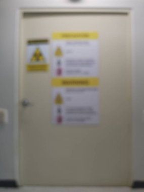 Uyarı işaretleri bulanık arka planı olan X-ray odası kapısı