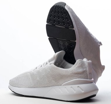 Stüdyo arka planında izole edilmiş bir çift beyaz spor ayakkabısı.