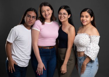 Gri stüdyo arka planında dört genç Latin kökenli izole edilmiş.