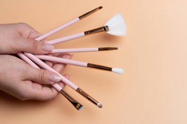 Makyaj teması. Beigr renk arkaplan üzerinde kadın el fırçaları farklı boyutlarda