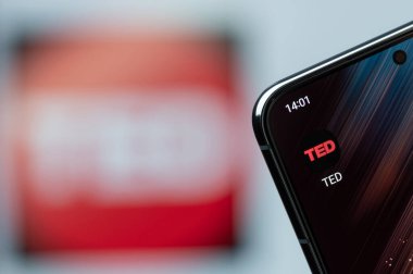 New York, ABD - 21 Ağustos 2023: Akıllı telefon ekranında TED uygulamasını kullanarak bulanık logo arka planına yakın çekim