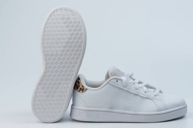 Stüdyo arka planında izole edilmiş kahverengi kamuflaj lekeli beyaz deri klasik spor ayakkabılar.