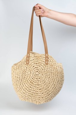 Yuvarlak bej renkli saman torbası elle izole edilmiş.