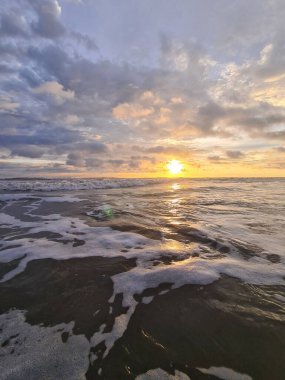 Oldukça tropik bir günbatımı arka planı. Dalgalar köpüklü okyanus