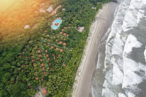 Plajda temiz hava aracı manzaralı tropikal doğa arka planında büyük bir otel.