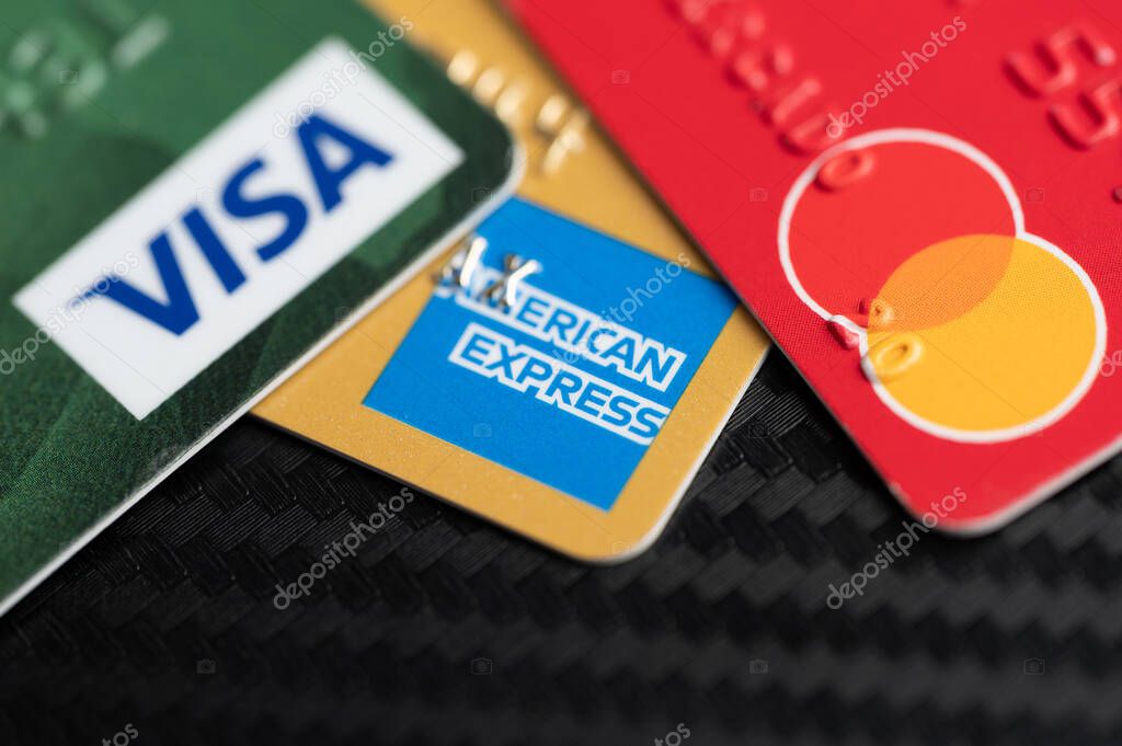 New York, USA - August 2, 2023: Visa master and american express debit cards on black table clsoe up view