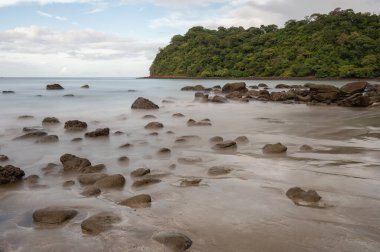 İpeksi deniz suyundaki kayalar. Deniz kıyısında bir sürü kahverengi taş