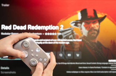 New York, ABD - 20 Şubat 2023: Oyuncu elinde joystick ile Xbox konsolunda yeni Red Dead Redemption Game 'i başlattı