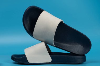 stduio arka planında koyu mavi ve beyaz parmak arası terlikler