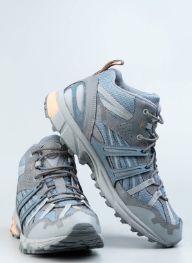 Stüdyo arka planında izole edilmiş bağcıklı gri ve mavi çizmeler.