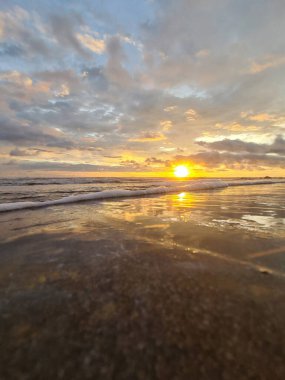 Okyanus sahilinde gün batımı. Tropikal havada ıslak kum