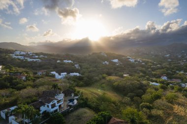 Şatafatlı villalar gün doğumunda altın ışıklı hava aracı görüntüsü