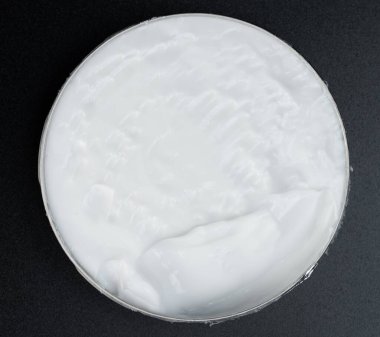 Stüdyo arka planında beyaz kremalı bir kutu aç