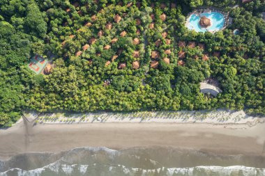 Okyanus sahili kıyı şeridi insansız hava aracı manzarasının yanındaki cennet tropikal otel.