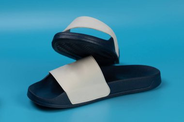 Mavi stüdyo arka planında izole edilmiş rahat bir çift terlik.