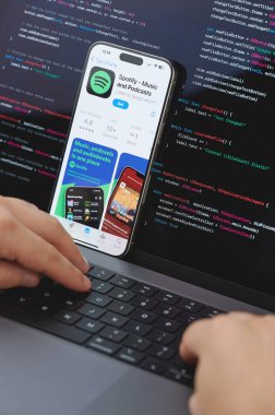 New York, ABD - 23 Şubat 2024: Dizüstü bilgisayarda elleri klavyede yeni Spotify müzik uygulaması için kod