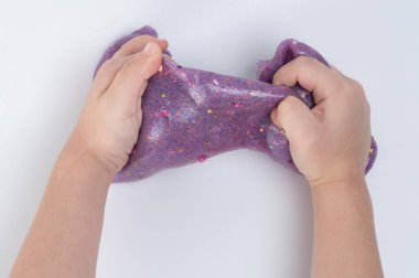 Çocuk mor renkli balçık parçasıyla oynuyor. Yakından bak.