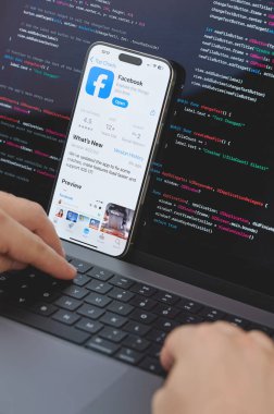 New York, ABD - 23 Şubat 2024: Dizüstü bilgisayarda elleri klavyede yeni Facebook uygulaması için kod