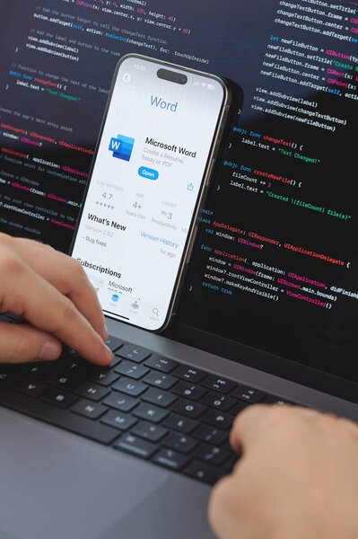 New York, USA - February 23, 2024: Code for new Microsoft word video app in laptop screen with hands on keyboard