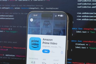 New York, ABD - 23 Şubat 2024: Amazon Prime videosu iphone ekranında bulanık kod programlama arka planında