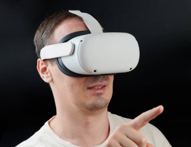 New York, ABD - 15 Mart 2024: Siyah stüdyo arka planında Meta Quest 2 portresi ile VR realitesini kullan