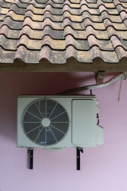 Klima dışarıda, çatı kiremitleri altında boru bağlantısı ev ünitesi var. 