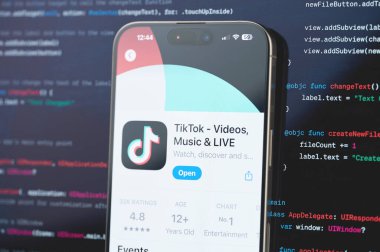 New York, ABD - 23 Şubat 2024: TikTok bulanık kod programlama arka planında iPhone ekranında