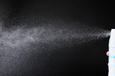 Deodorantlardan püskürtülen duman siyah stüdyo arka planında izole edilmiş.
