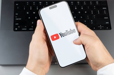 New York, ABD - 6 Nisan 2024: Popüler Youtube mobil uygulaması akıllı telefon ekranında dizüstü bilgisayarın klavye arka planında