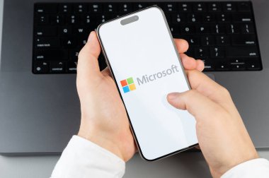 New York, ABD - 6 Nisan 2024: Akıllı telefon ekranındaki popüler Microsoft mobil uygulaması dizüstü bilgisayarın klavye arka planında