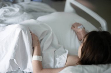 Hasta çocuk hastane yatağında dinleniyor.