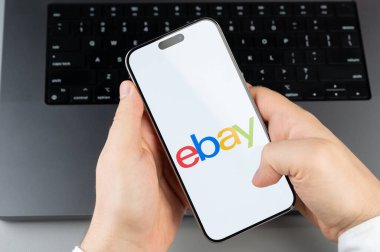 New York, ABD - 6 Nisan 2024: Popüler Ebay mobil uygulaması akıllı telefon ekranında dizüstü bilgisayarın klavye arka planında